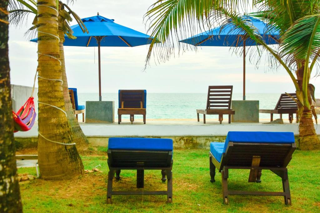 un grupo de sillas y sombrillas en la playa en Oriental Rest, en Hikkaduwa