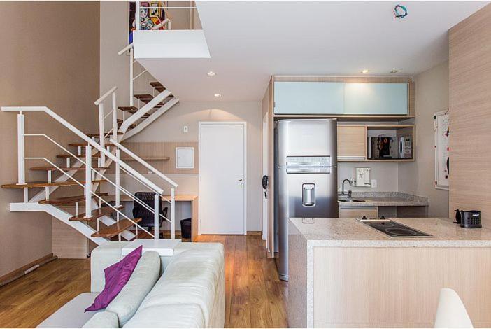 a living room with a white couch and a spiral staircase at Duplex NYC Berrini 2 dormitórios - ao lado do WTC in Sao Paulo