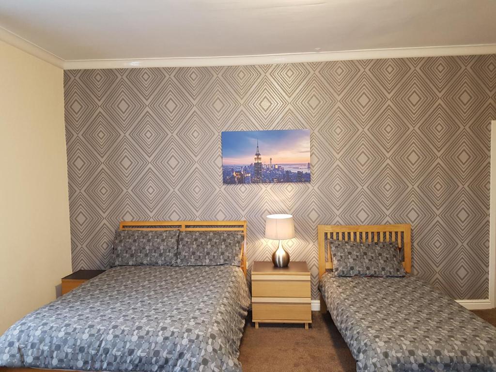 a bedroom with two beds and a picture on the wall at Brookfield Hotel in Leeds