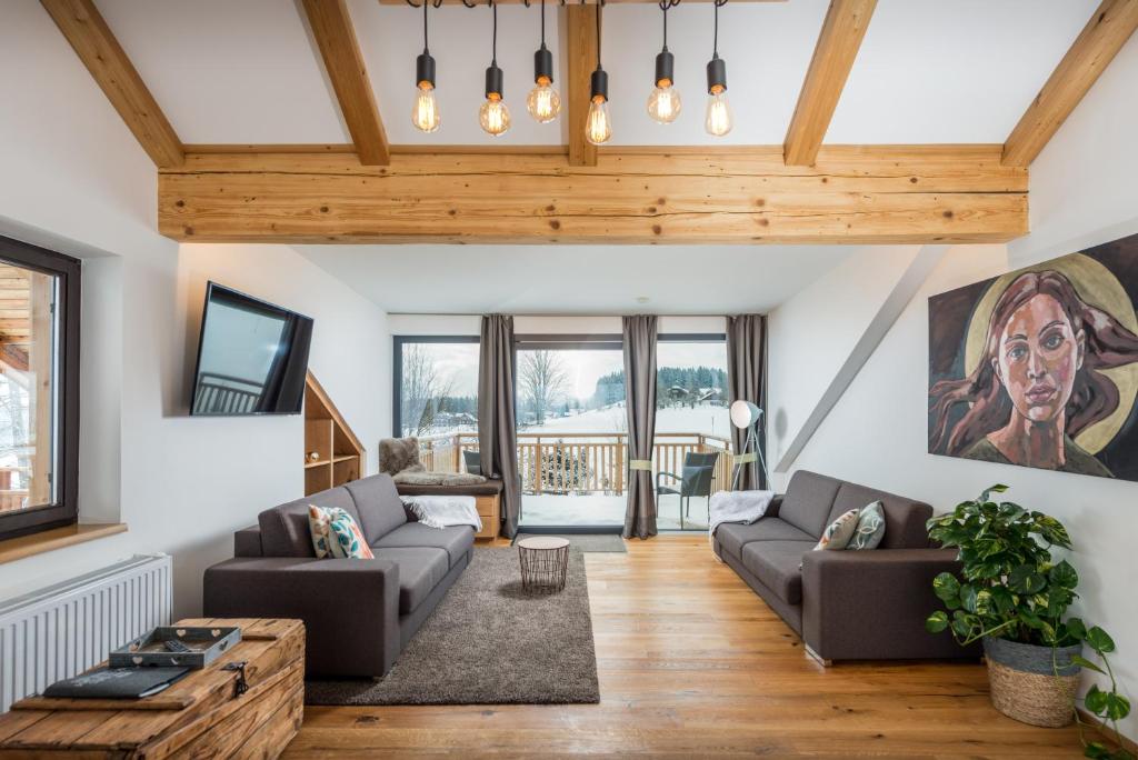 a living room with two couches and a table at Naturchalet Höflehner in Ramsau am Dachstein