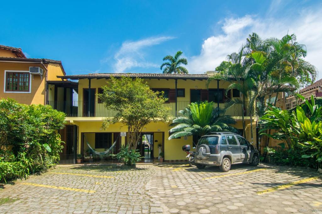 un coche aparcado frente a un edificio amarillo en Pousada Miracolo, en Paraty