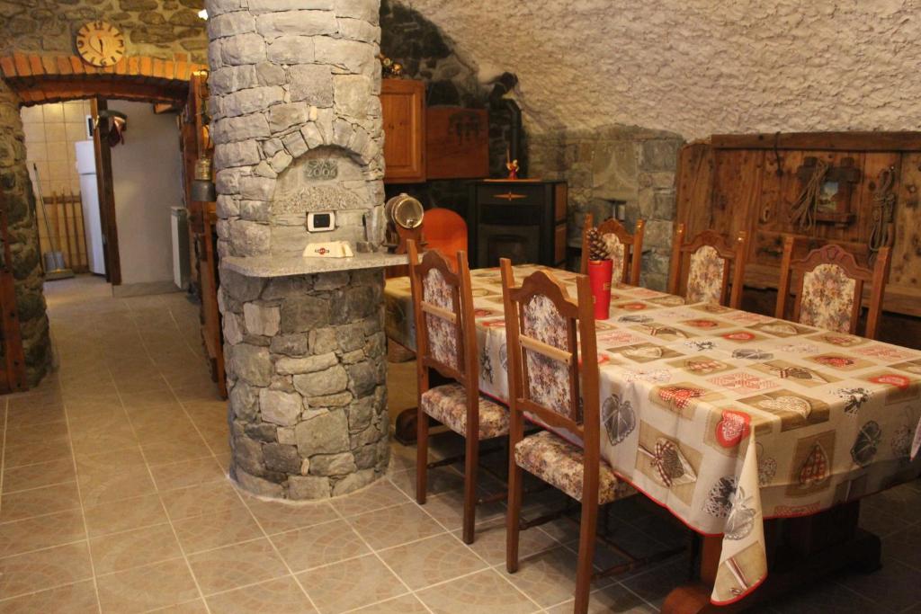 a dining room with a table and a stone oven at Fiocco di Neve in Montjovet