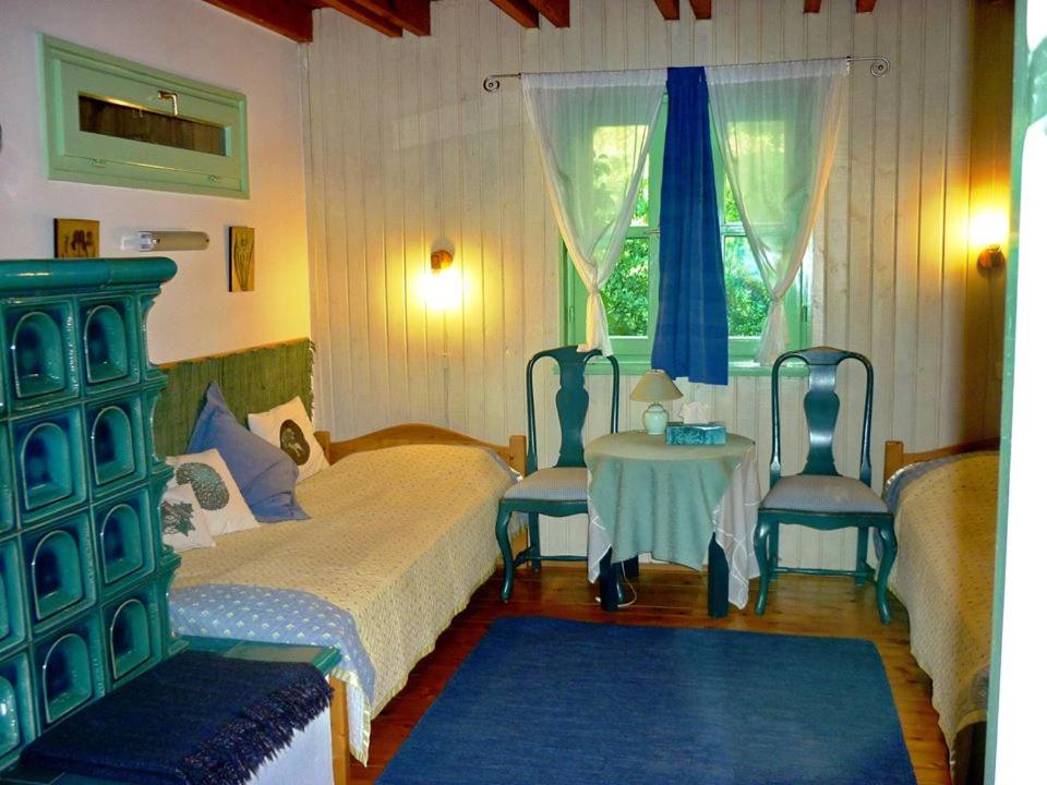 a bedroom with a bed and two chairs and a table at Rosehill Cottage in Orbányosfa