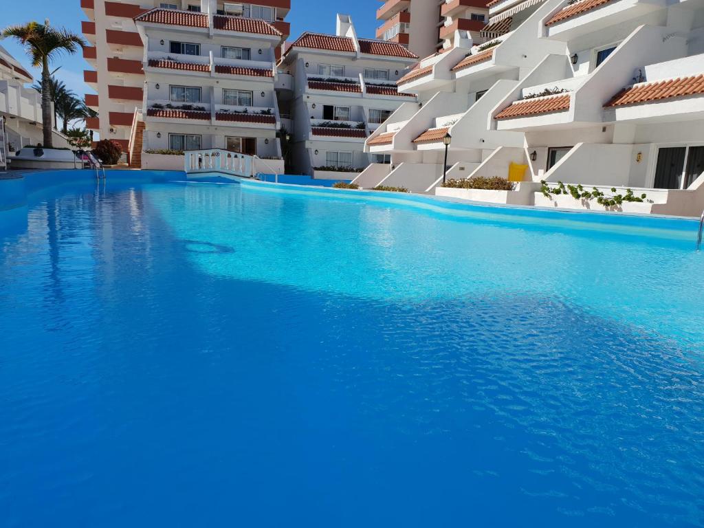 アロナにあるCasa Las Flores with heated pool, only 490 meters to the beach, balcony, wifiの建物の前に青い水のスイミングプール