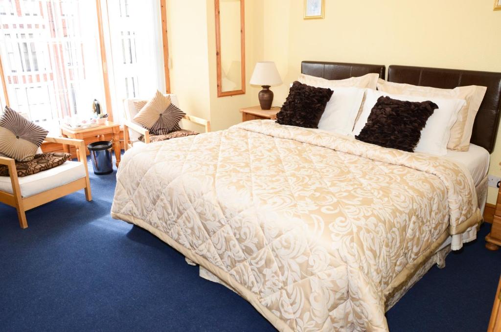um quarto com uma grande cama branca com almofadas em Pinewood House em Whitby