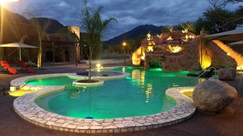 a swimming pool in a resort at night at La Guadalupe Cabañas in La Rioja