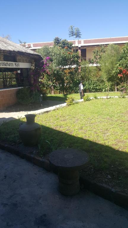 un parque con un banco frente a un edificio en Jerusalem Hotel Lalibela, en Lalibela