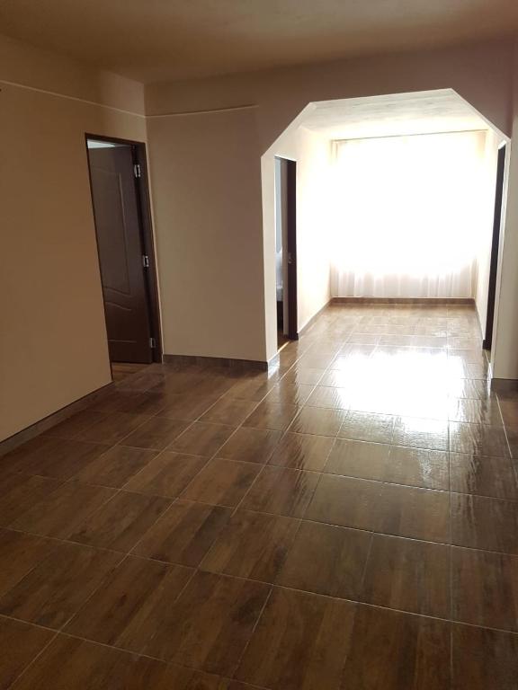 an empty room with a wooden floor and a large window at Cabana Merișor in Poiana Mărului