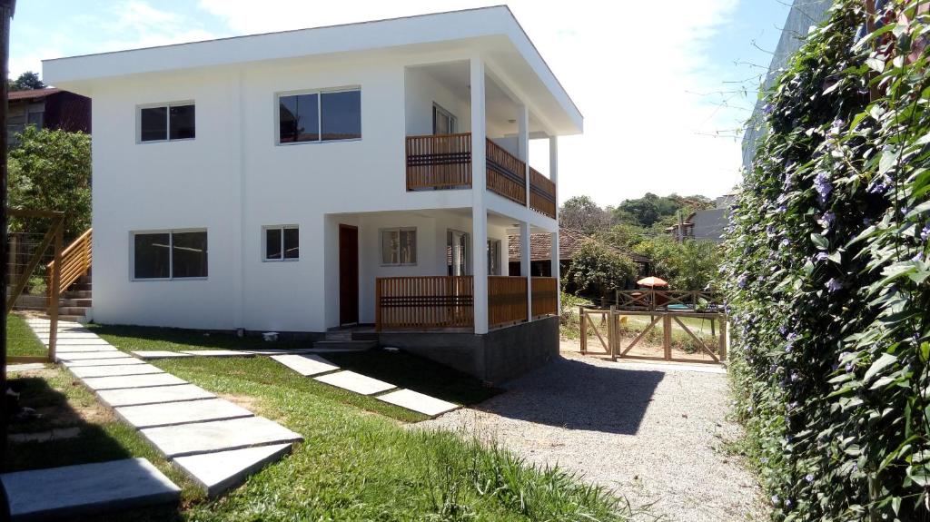 a white house with a fence in front of it at Casablanca do Rosa in Praia do Rosa