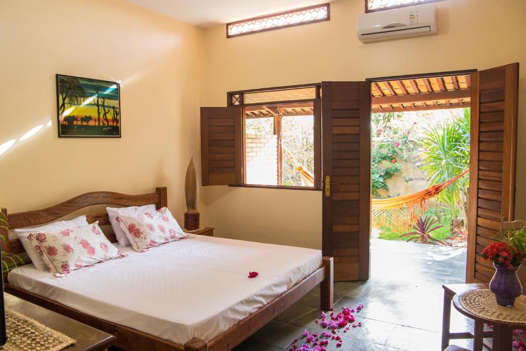 um quarto com uma cama e uma porta aberta em Hotel Pousada Arco Iris em Barra de Santo Antônio