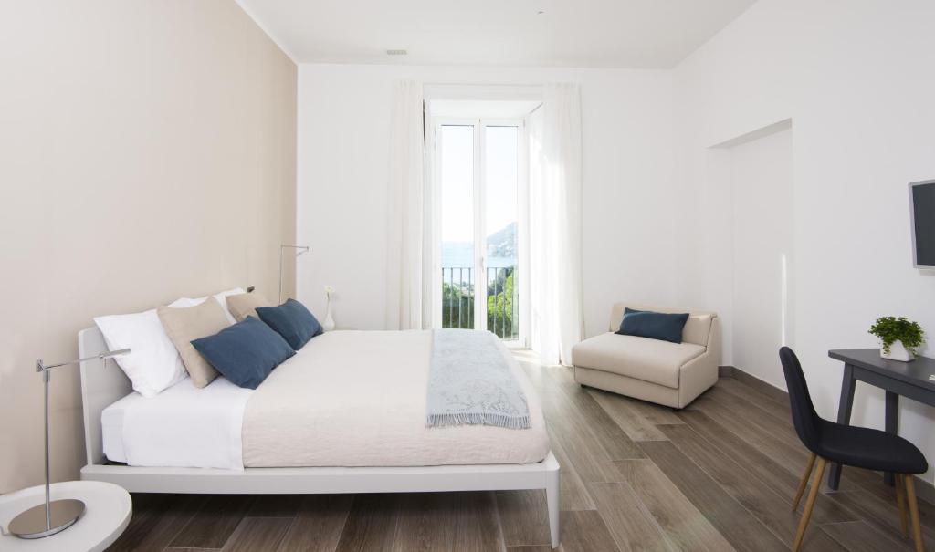 Habitación blanca con cama y escritorio en Ambrosea Amalfi Coast B&B, en Vietri