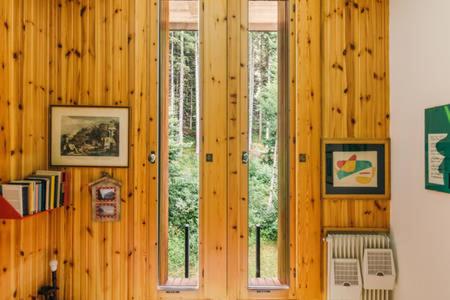 a room with wood paneled walls with two windows at CENTRAL WOODEN CHALET WITH FOREST VIEW in Madonna di Campiglio