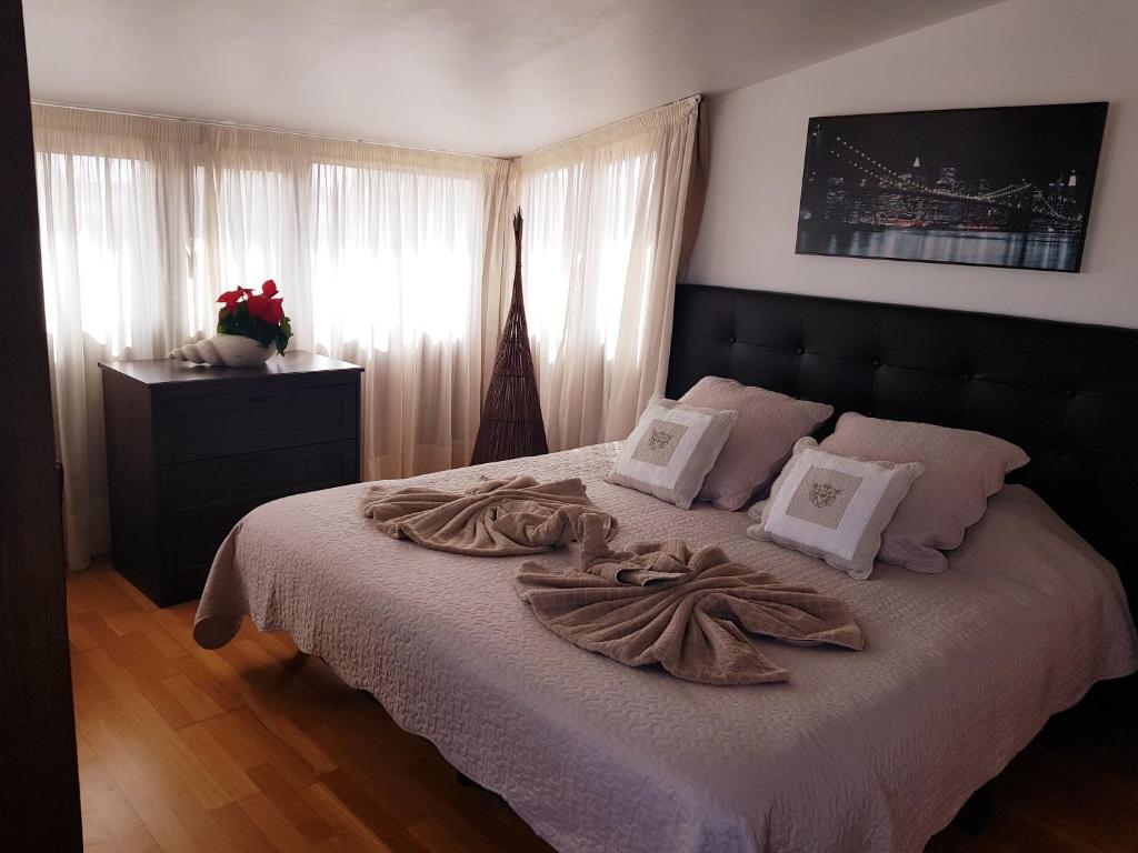 a bedroom with a bed with white sheets and towels on it at VILLA 16 LUJO A 200 M DEL MAR in Corralejo