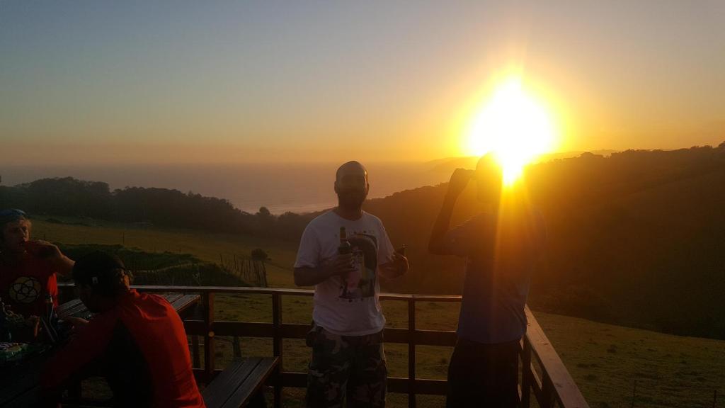 a group of people standing in front of the sunset at The Wild Farm Backpackers in Wilderness