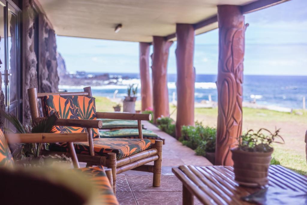 a porch with chairs and a view of the ocean at Cabañas & Hostal Tojika in Hanga Roa