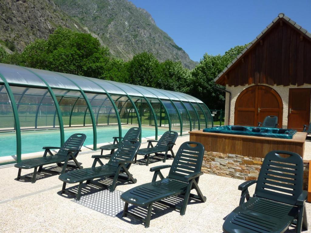 un groupe de chaises assises à côté d'une piscine dans l'établissement Les Prés-Ronds, à La Chapelle-en-Valgodemard