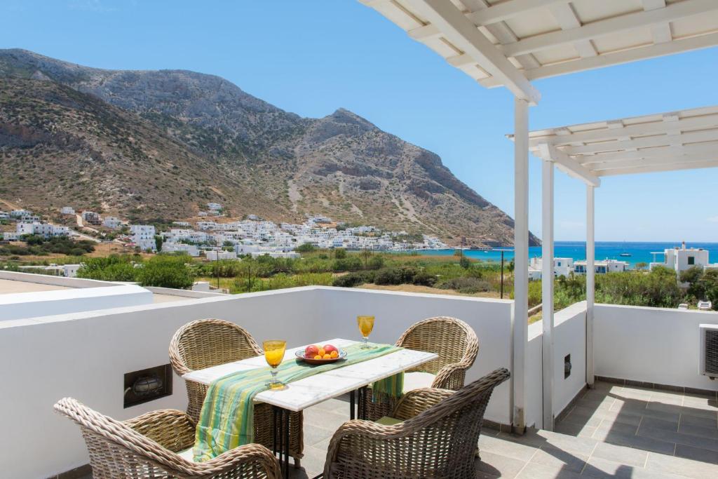a table and chairs on a balcony with a view of the ocean at Villa Areto in Kamares