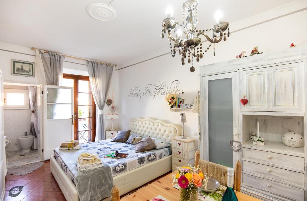 a bedroom with a bed and a chandelier at La Bomboniera Chic di Pietrasanta in Pietrasanta