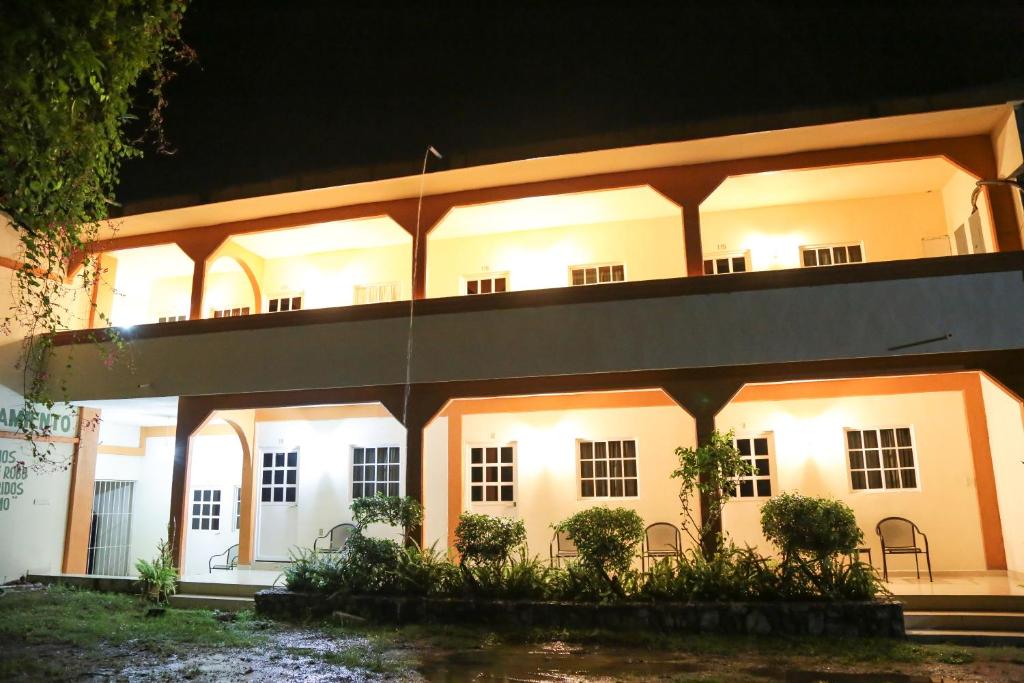 a large white building with lights on at night at Hotel Santa Rita in Huichihuayán