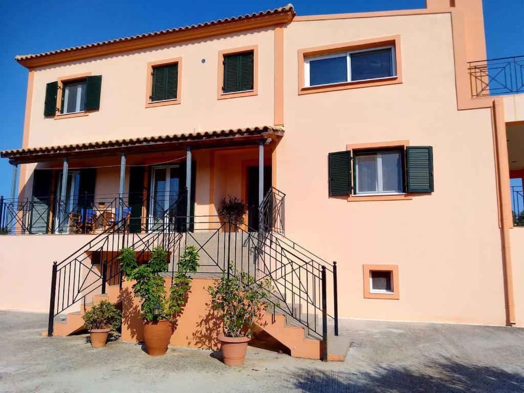 uma casa com vasos de plantas em frente em Margaret's House em Kefalonia