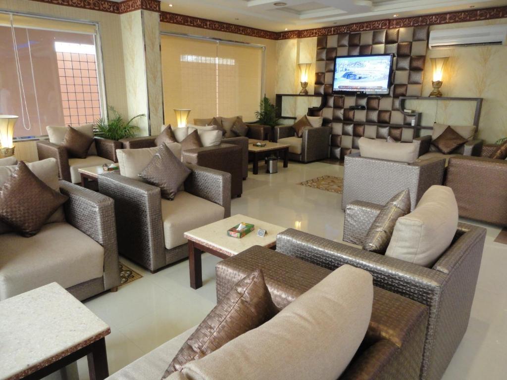 sala de estar con sofás y TV de pantalla plana. en فندق فيناس, en Riad