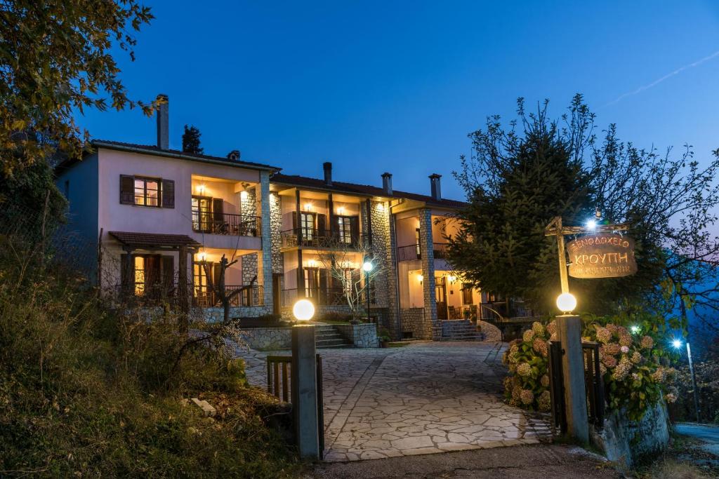 una casa grande con luces delante de ella por la noche en Hotel Kroupi, en Elati