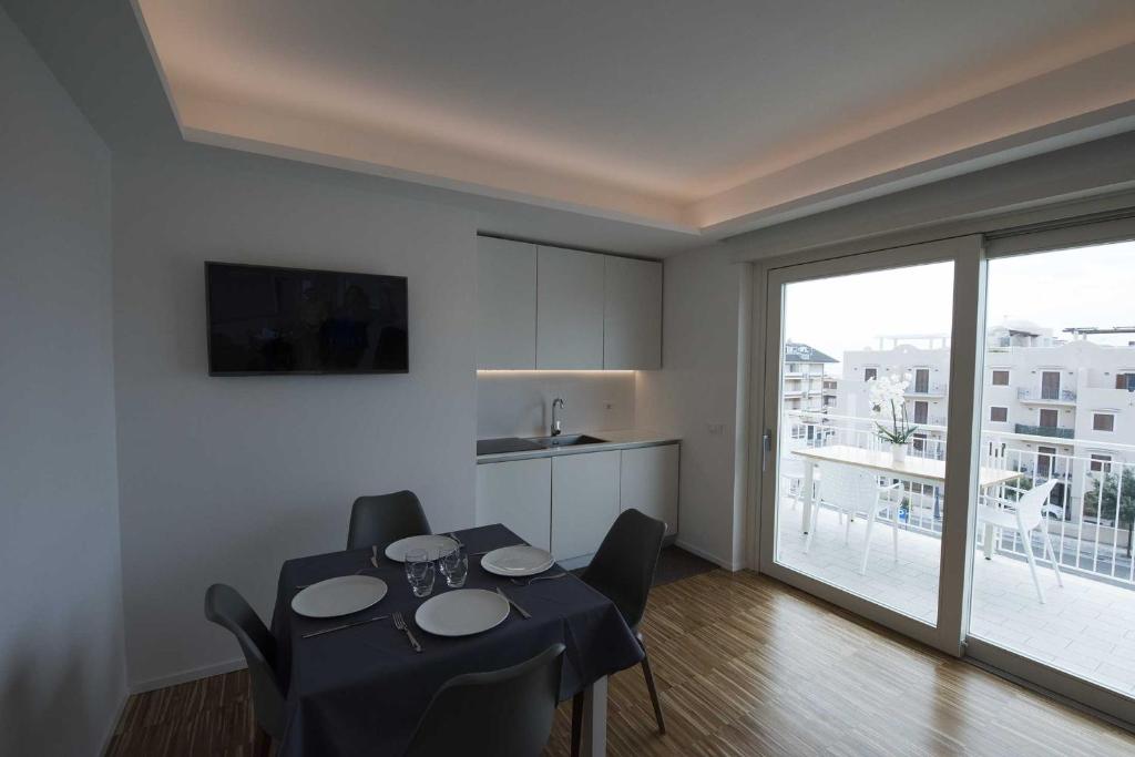 a living room with a table and chairs and a kitchen at apARTments Sperlonga in Sperlonga