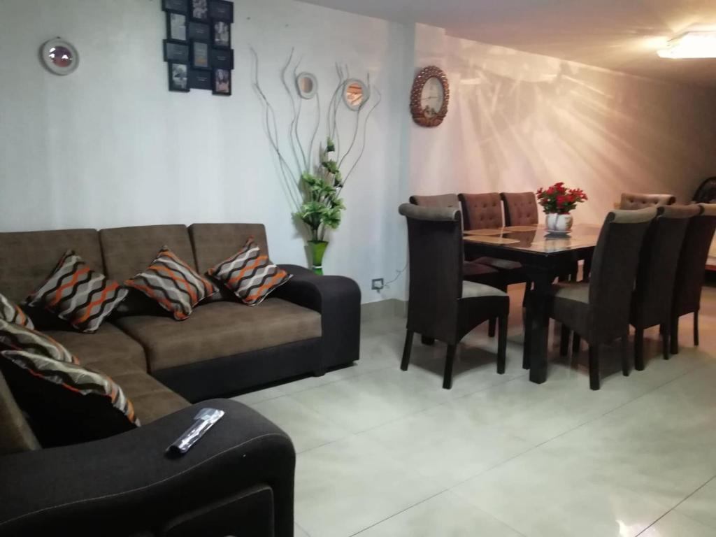 sala de estar con sofá, mesa y sillas en CASA F'BALUA, en Tacna