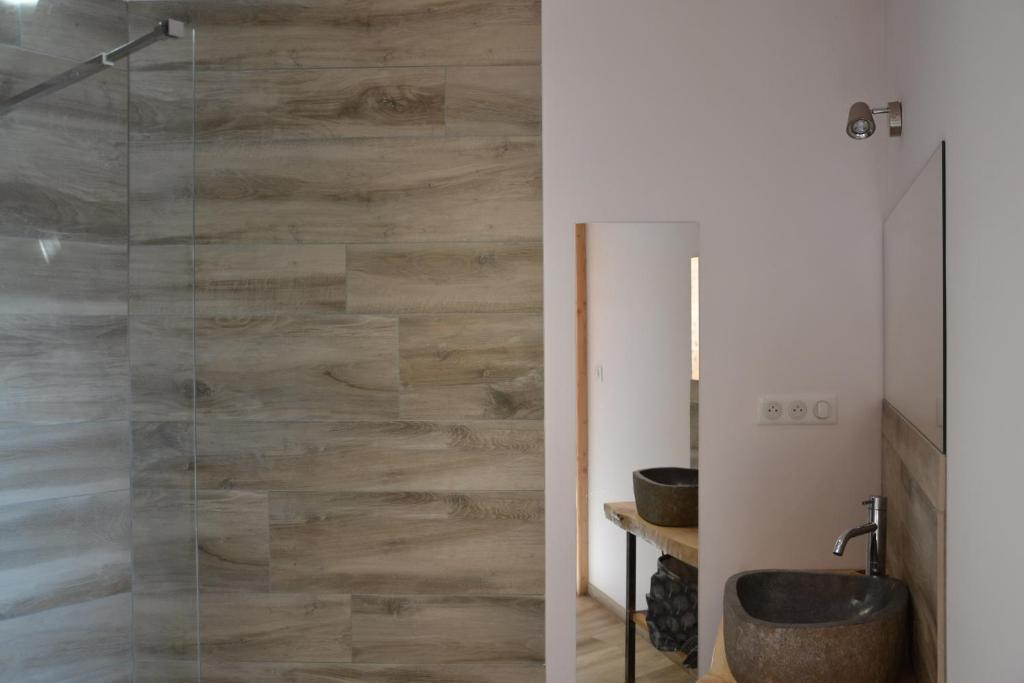 a bathroom with a glass shower with a sink at Bulle de Bois, écolodge insolite avec spa privatif au milieu des volcans - Bulles d&#39;Herbe in Queyrières