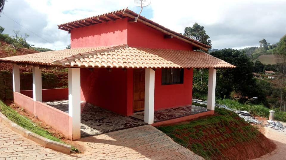 une maison rouge avec un toit en carrelage dans l'établissement Rancho das Montanhas, à Muniz Freire