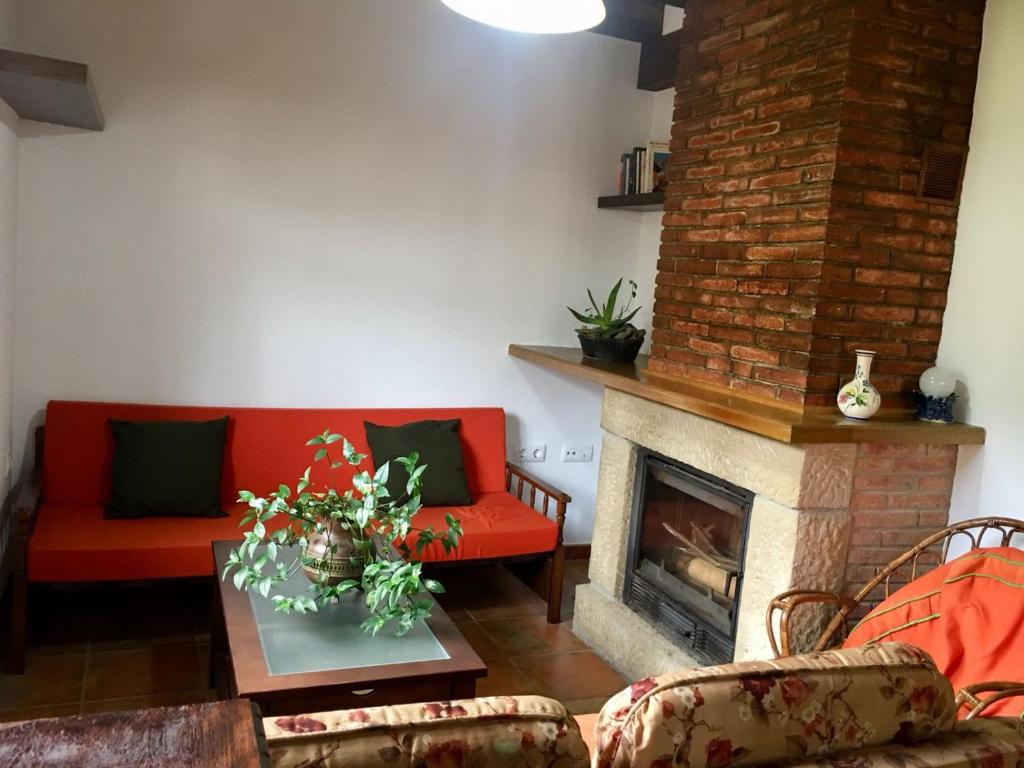 a living room with a red couch and a fireplace at La Casuca de Pumareña in Pumareña
