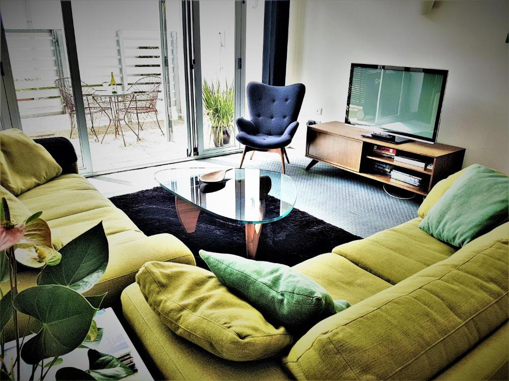 a living room with two couches and a television at Downtown Townhouse Special in Auckland