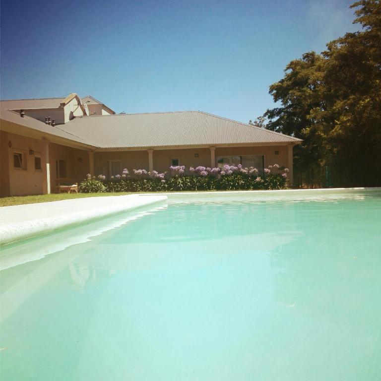 a house with a large pool of water in front of it at Villa Clarita Tandil in Tandil