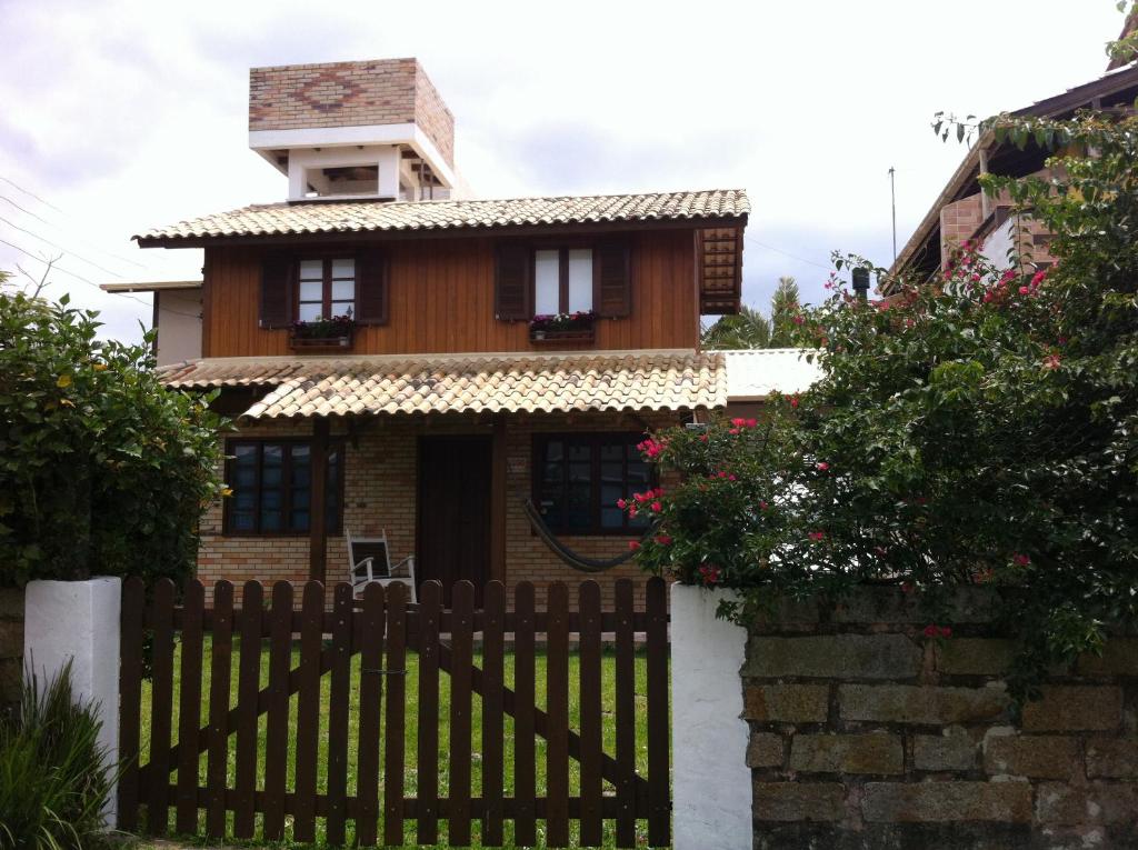 a house with a wooden gate and a fence at Encontro das Águas in Guarda do Embaú