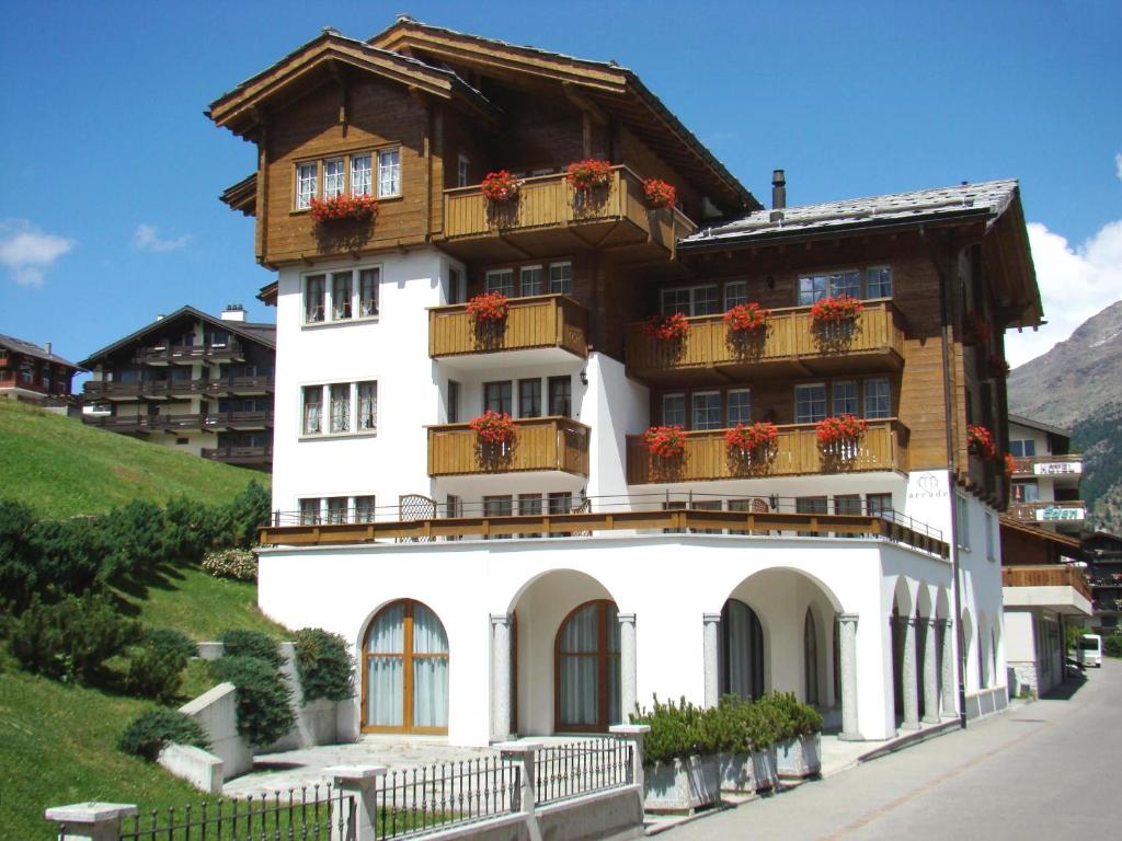 a building with flowers on the balconies on it at Arcade Apartments & Spa in Saas-Fee