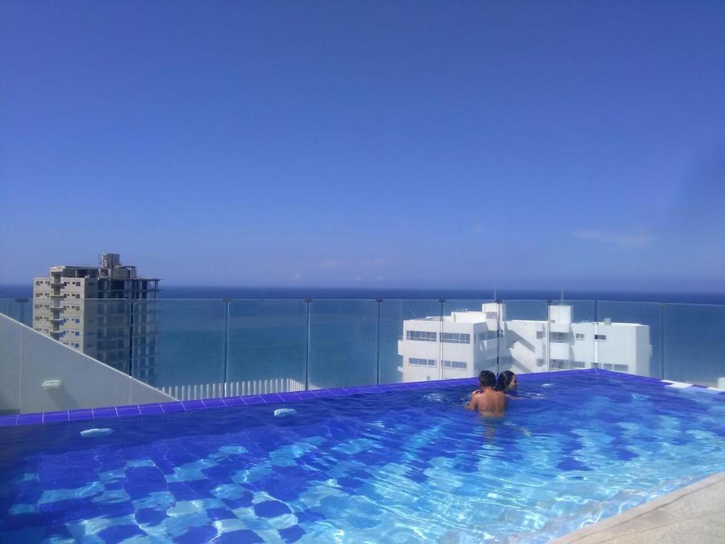 um homem numa piscina no topo de um edifício em Apartamento con salida al Mar em Santa Marta