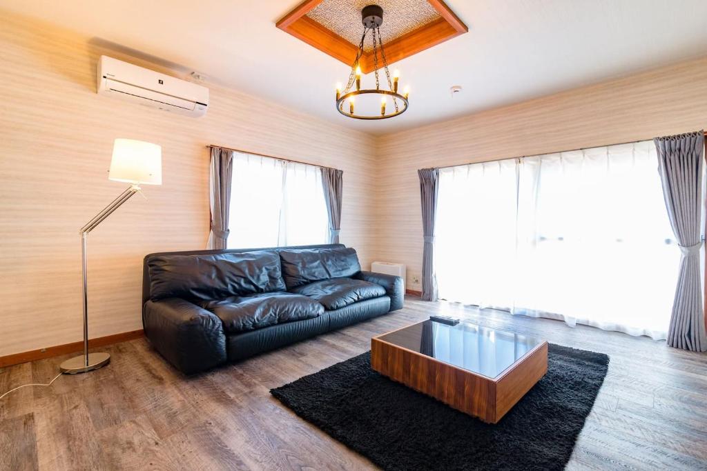 - un salon avec un canapé en cuir et une table basse dans l'établissement tocoro. Mt.Fuji Uzuki, à Fujikawaguchiko