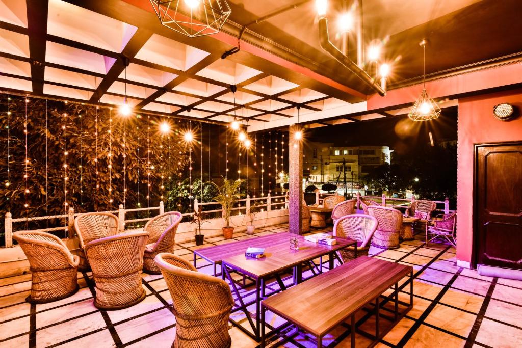 a patio with tables and chairs and lights at Hoztel Jaipur in Jaipur