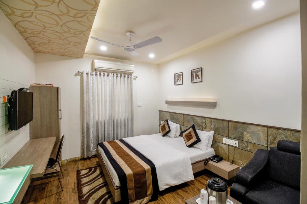 Habitación de hotel con cama y sofá en Hotel City Inn, en Ahmedabad