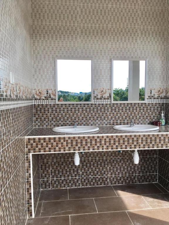 a bathroom with three sinks and two windows at Aneeda Inn in Pantai Cenang
