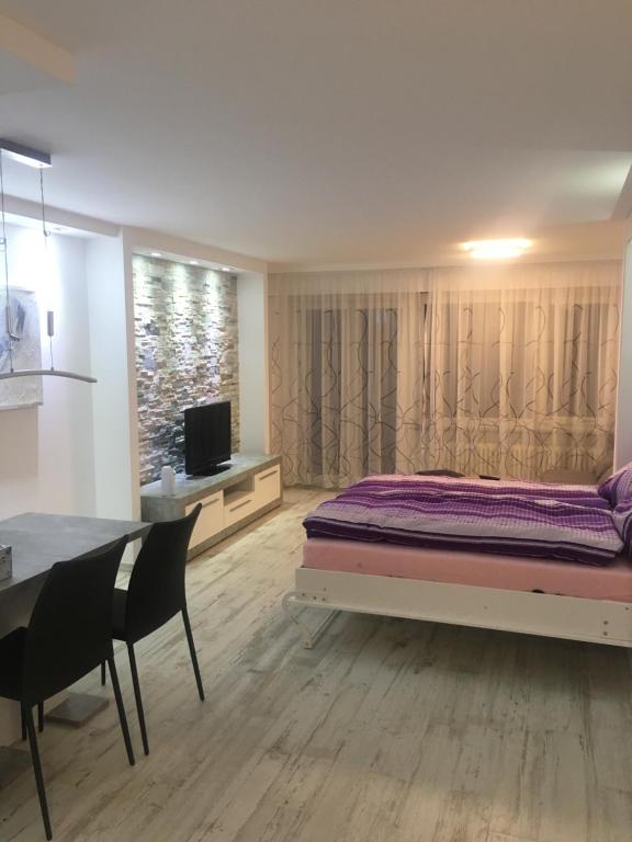 - une chambre avec un lit et une table à manger dans l'établissement Holiday 87, à Loèche-les-Bains
