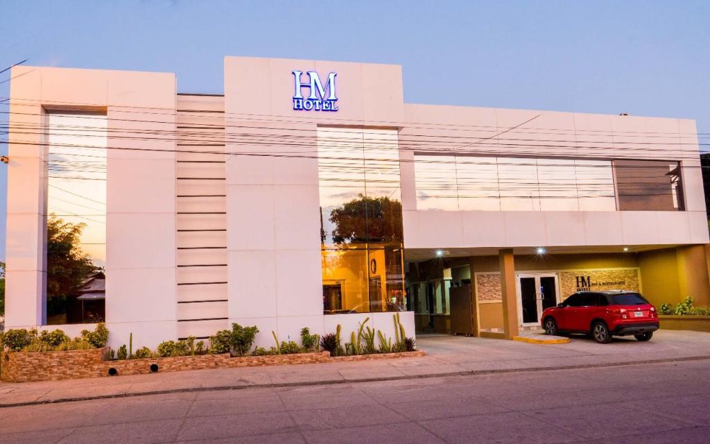 een gebouw waar een auto voor geparkeerd staat bij HM HOTEL in Choluteca