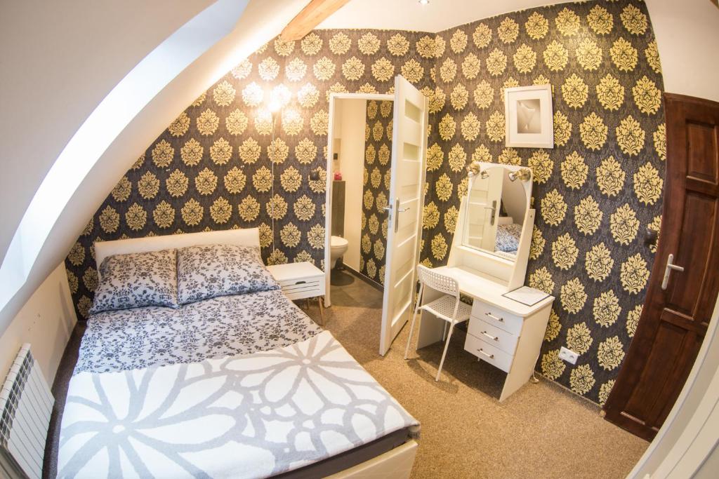 małą sypialnię z łóżkiem i lustrem w obiekcie Fitness Hostel - restauracja, darmowy parking i siłownia we Wrocławiu