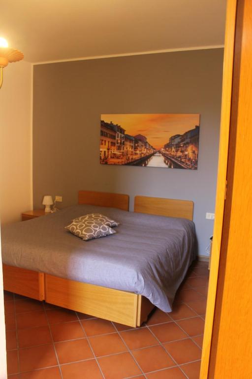 una camera da letto con un letto e un dipinto sul muro di ALBERGO LA SCALETTA a Cantù