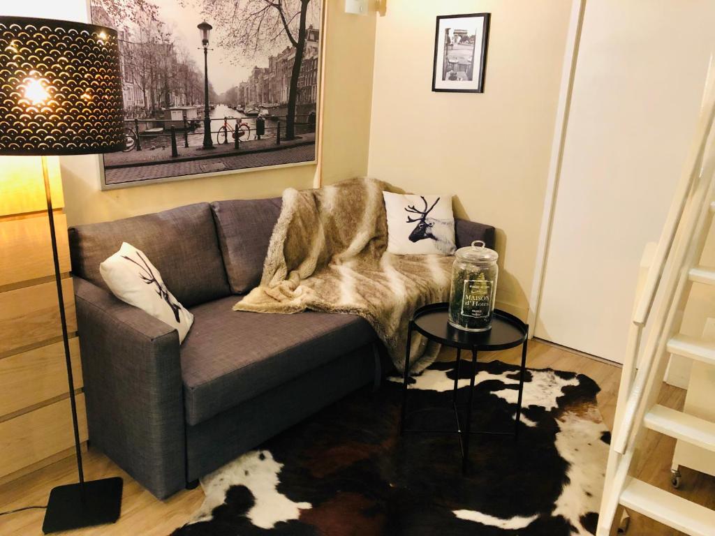 un salon avec un canapé et une table dans l'établissement Le Petit Neptune, à Versailles