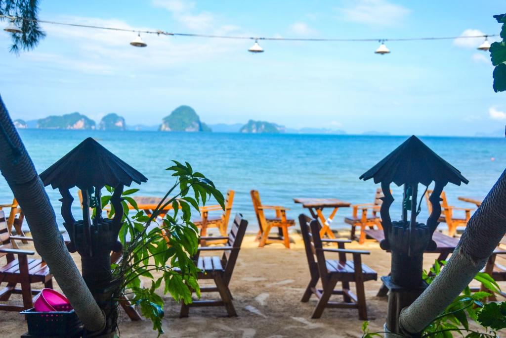 a group of tables and chairs on the beach at Baan Tubkaek Hotel in Tab Kaek Beach