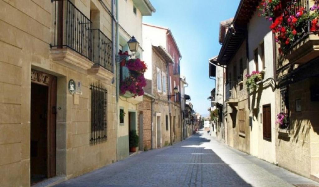 una calle vacía en una ciudad con edificios y flores en Casa Jacobea, en Grañón
