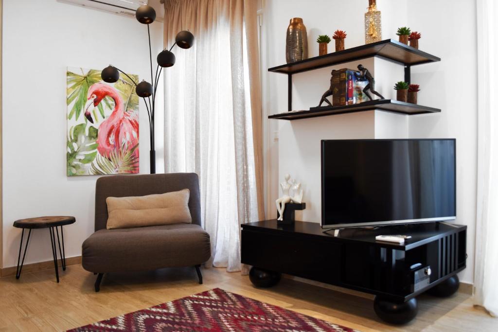 ein Wohnzimmer mit einem Flachbild-TV und einem Stuhl in der Unterkunft Cosmos n Armonia Apts.(Must) in Thessaloniki