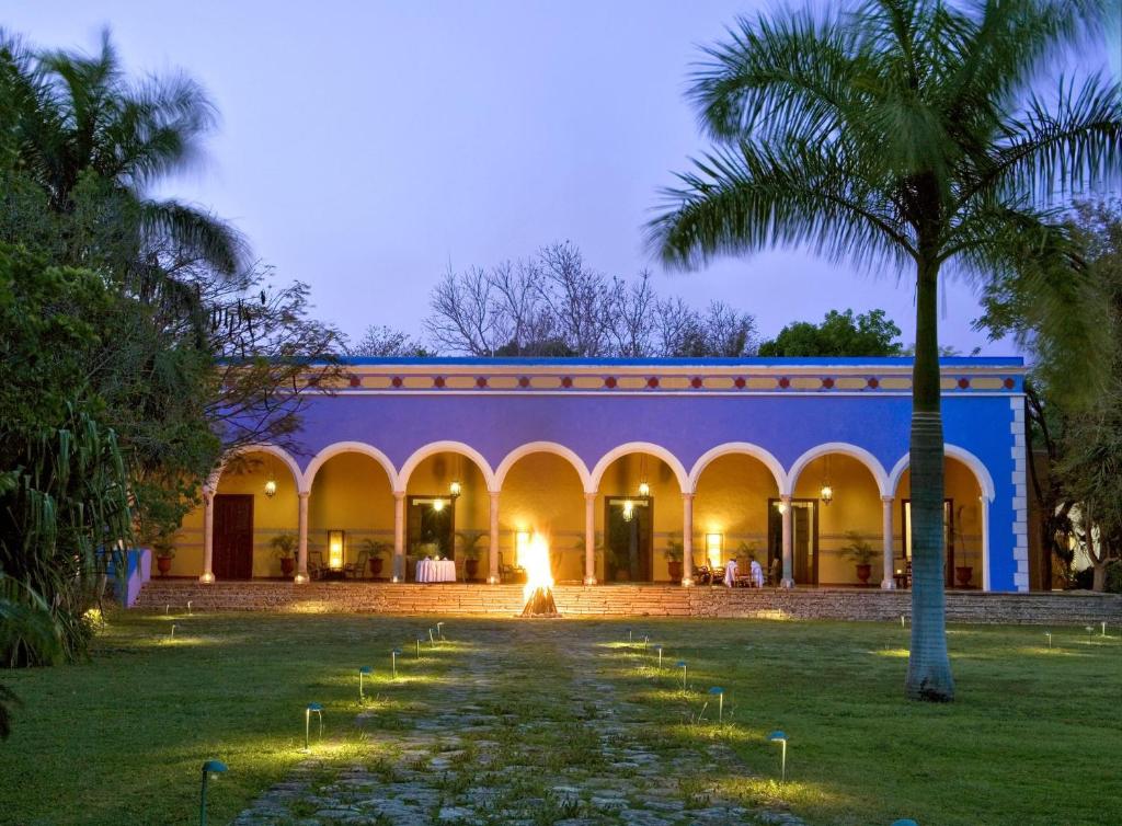 a building with a courtyard with a palm tree at Hacienda Santa Rosa in Santa Rosa