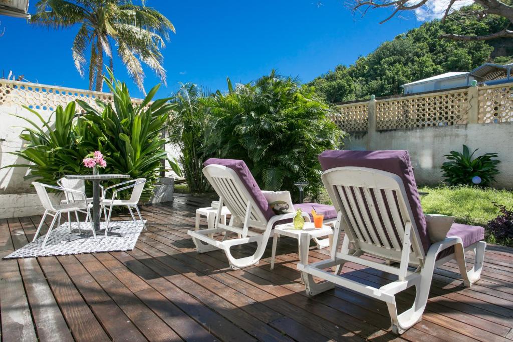 a group of chairs and tables on a deck at Hevea Hotel in Grand Case